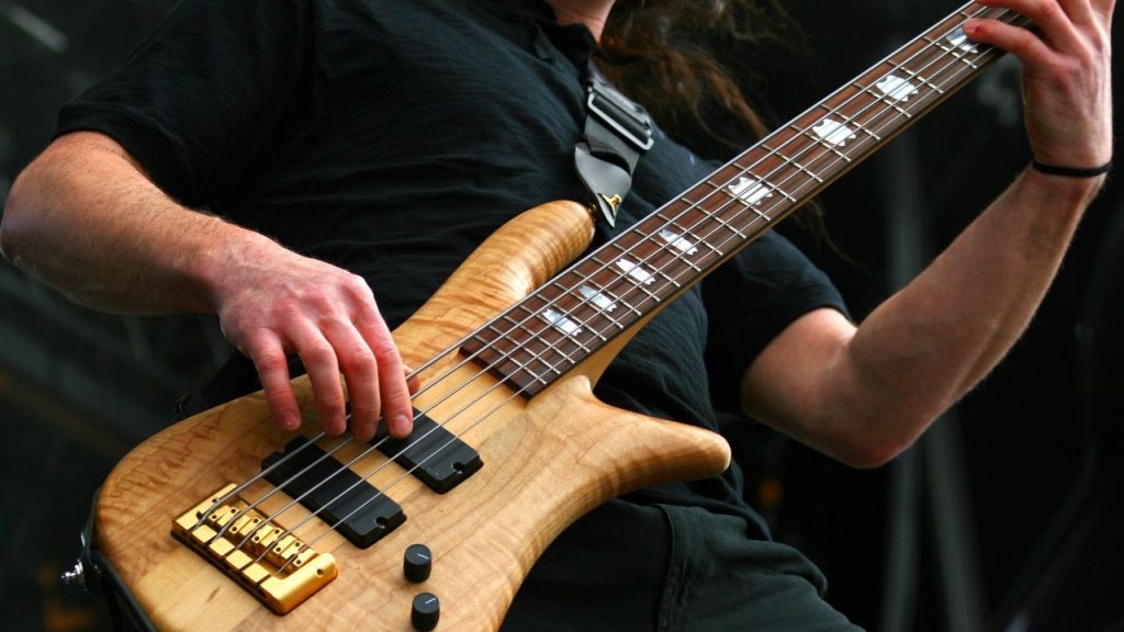 A musician playing a 5-string bass. 