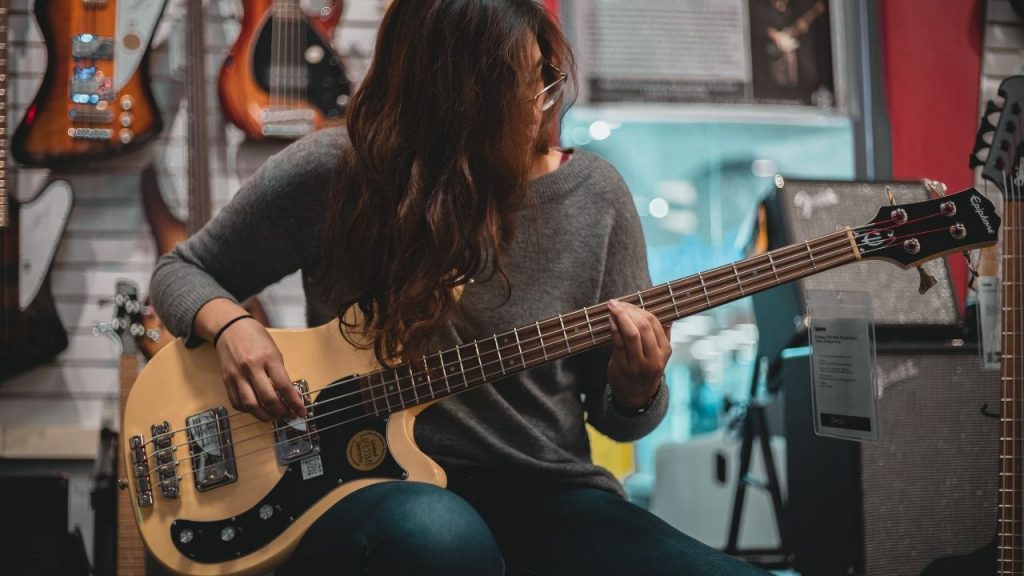 A beginner bass player trying a four-string bass. 