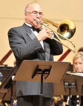 A picture of famous trombone player Joseph Alessi performing with an orchestra. 