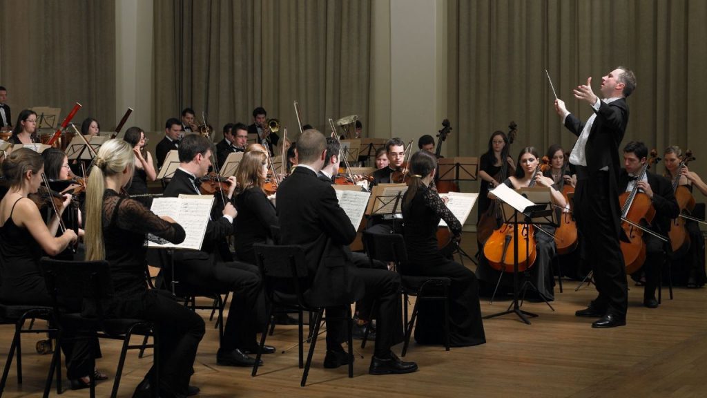 An orchestra playing live on stage. 