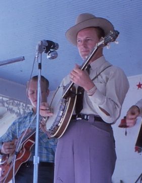 A photo of Don Reno playing the banjo on stage.