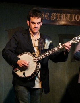 A photo of banjoist Noam Pikelny performing on stage.