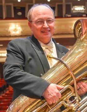 Tuba player Gene Pokorny holding his tuba