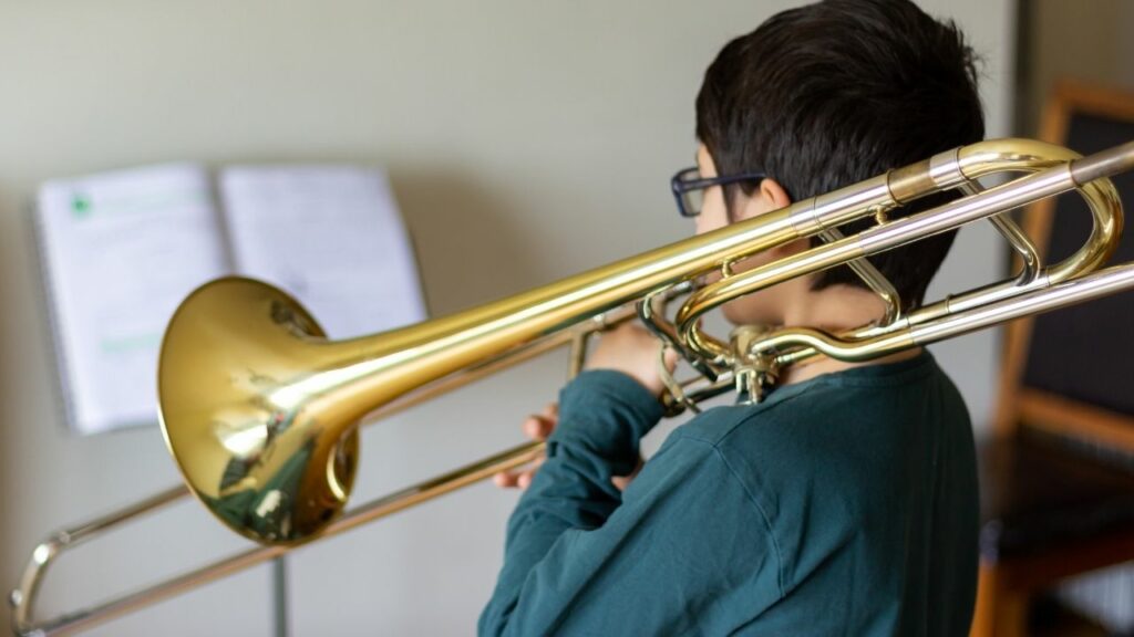 A kid practicing the trombone.