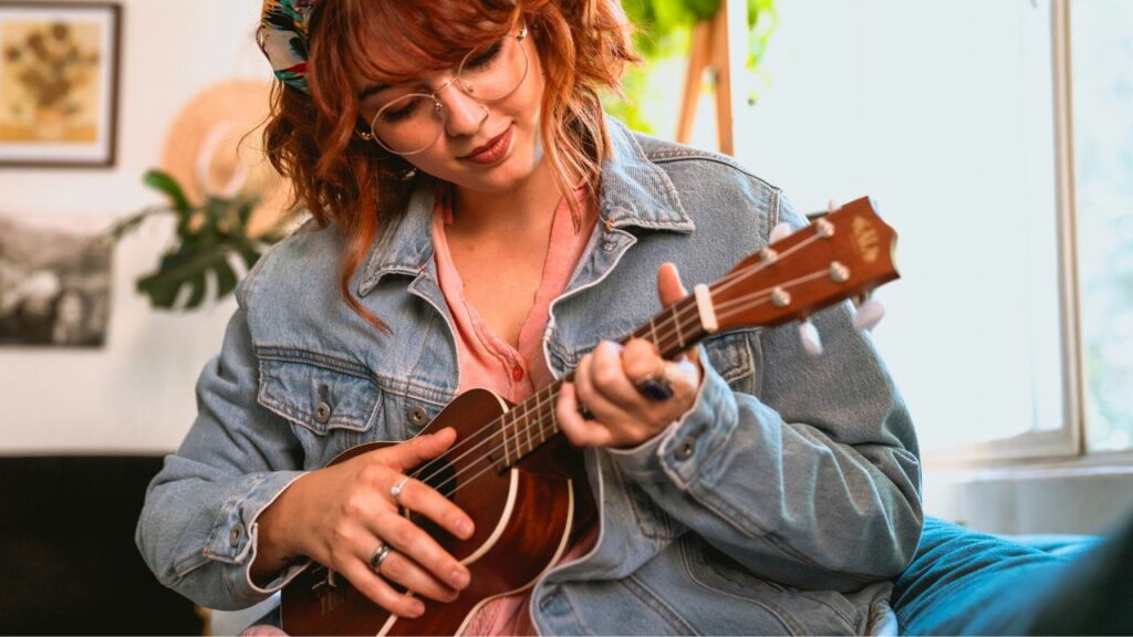 A woman holding a ukulele