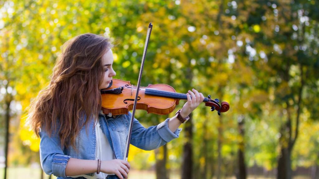 A woman playing a violin at the park