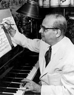 Movie composer Max Steiner writing on a music sheet.