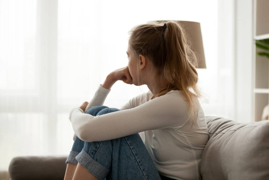 Side View Young Woman Looking Away At Window Sitting On