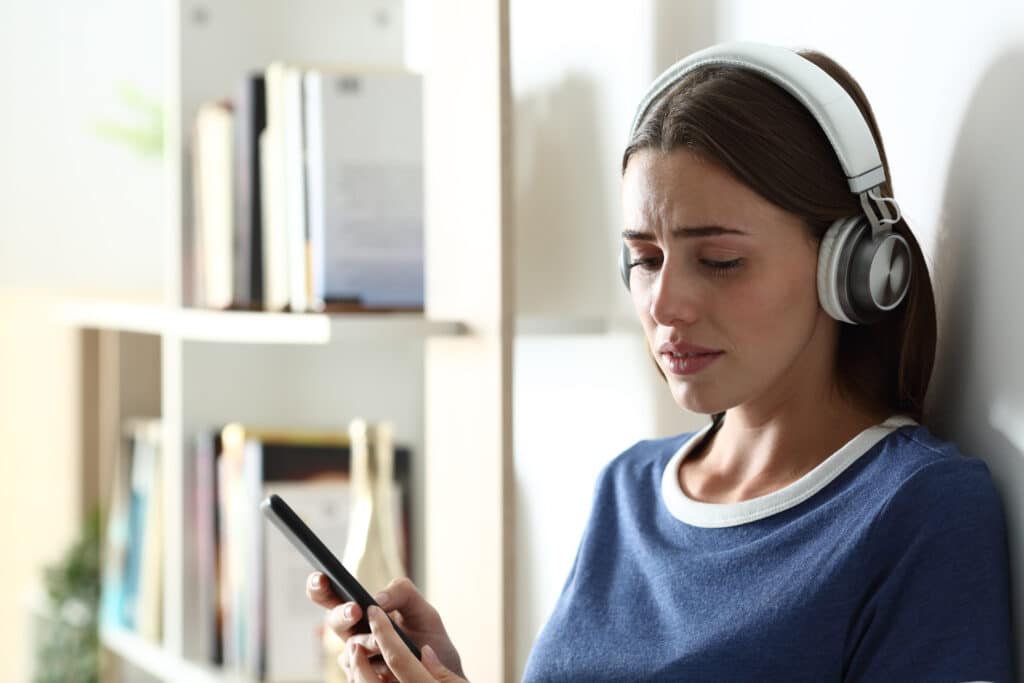 Sad Teen Complaining Listening To Music Looking Down And Crying