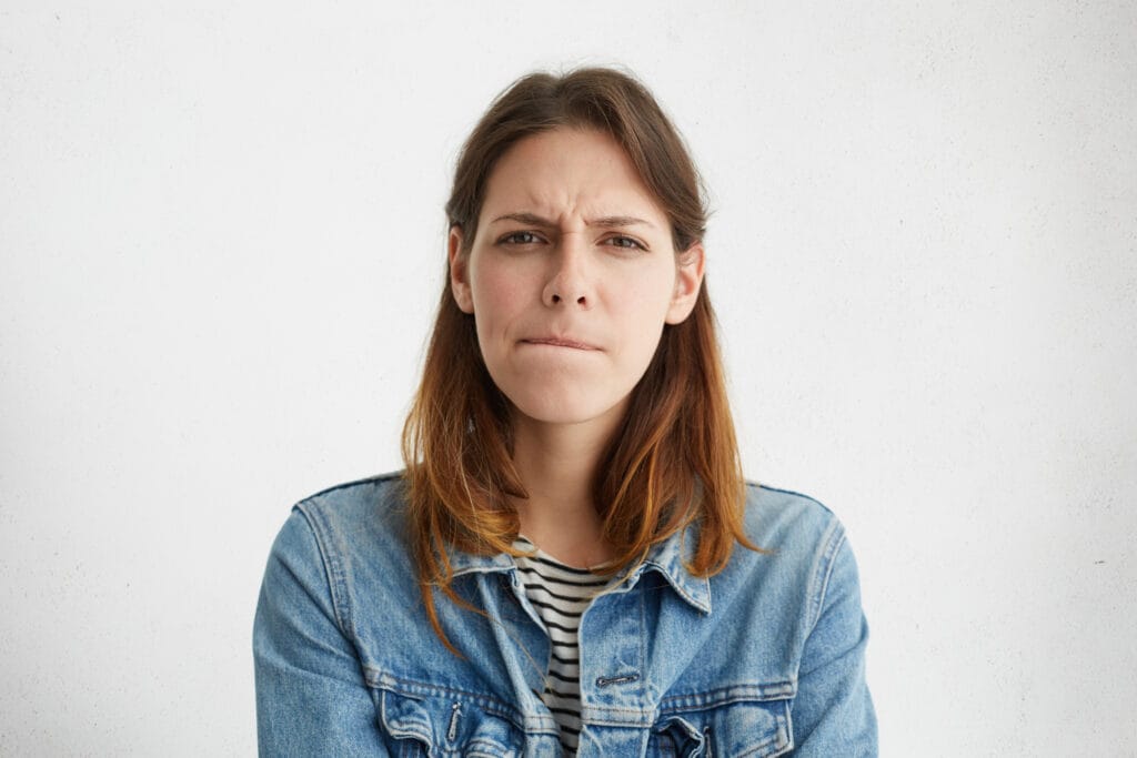 Headshot Of Indecisive Confused Young European Woman In Denim Wear