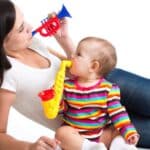 Mother and baby girl having fun with musical toys