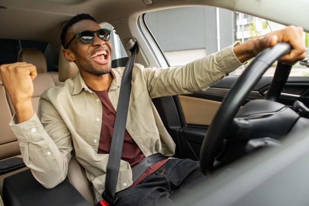 A Joyful African American In Glasses Dances In A Car 