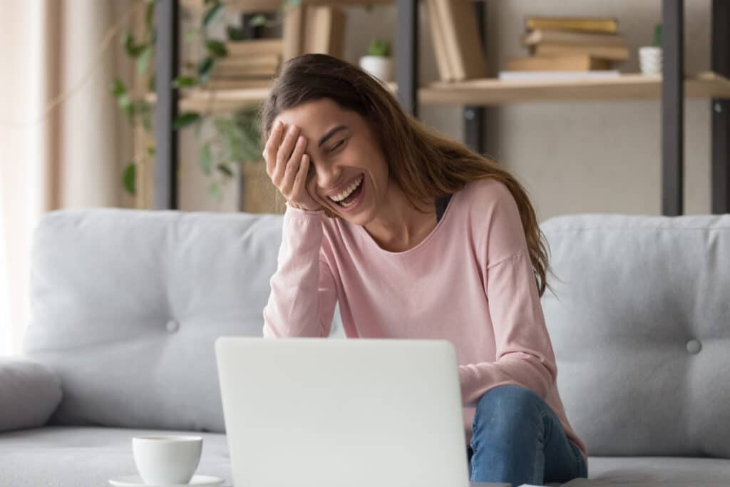 Laughing Woman Sitting On Sofa Watch Comedy Movie On Pc