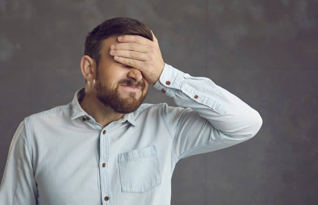 Businessman Covers Face With Hand. Guy Facepalms Feeling Ashamed Of