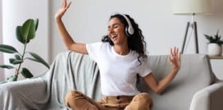 Woman In Sofa Listening To Music And Dancing